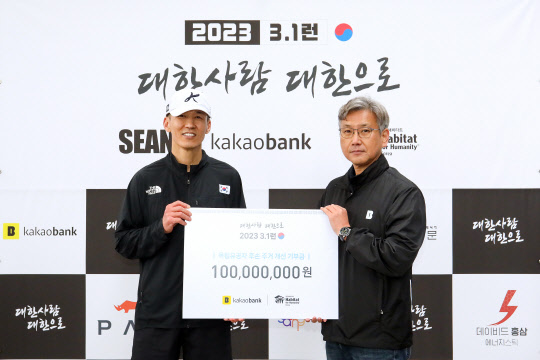 카카오뱅크가 독립유공자 주거지원 후원금 마련 기부 마라톤에 1억원을 기부했다고 밝혔다. 카카오뱅크 윤정백(오른쪽) ESG팀 팀장이 가수 션과 기념촬영하고 있다. 카카오뱅크 제공